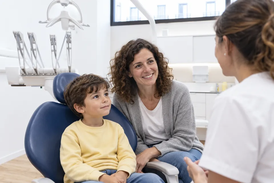Niño acompañado por su madre en la consulta dental